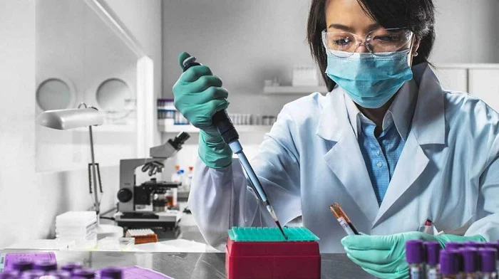 Scientist Pipetting Liquid In Test Tubes